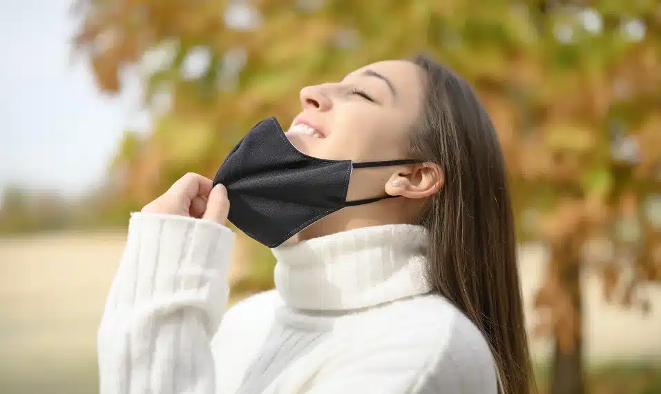 relaxed woman taking off mask scaled 1