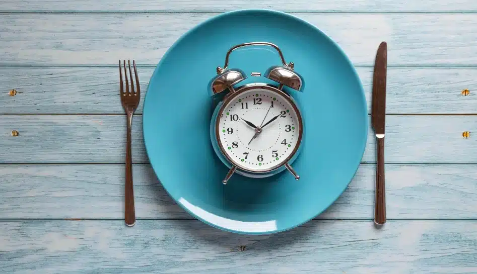 meal planning diet concept intermittent fasting concept with clock plate fork knife wooden table 1